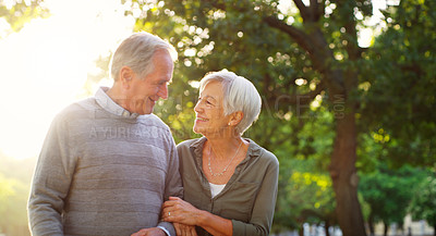 Buy stock photo Senior couple, walking and happy outdoor at a park with love, care and support for health and wellness. A elderly man and woman in nature for a walk, quality time and healthy marriage or retirement