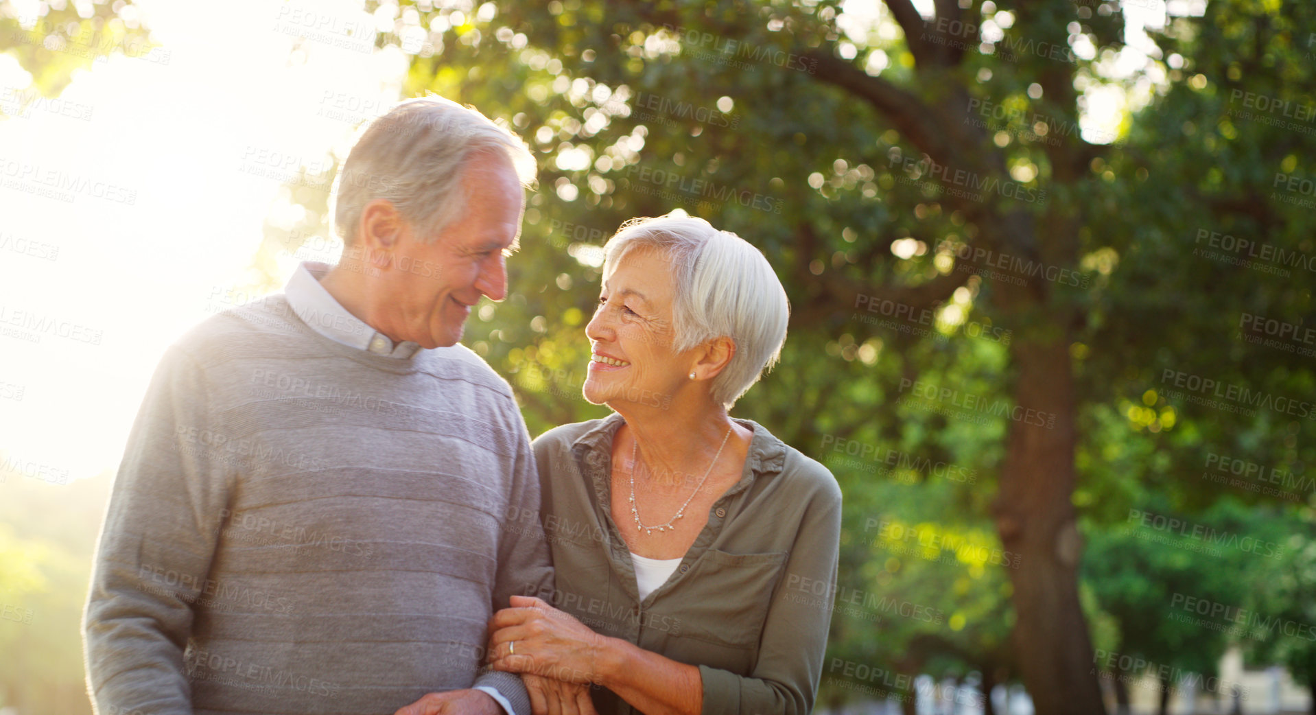 Buy stock photo Senior couple, walking and happy outdoor at a park with love, care and support for health and wellness. A elderly man and woman in nature for a walk, quality time and healthy marriage or retirement