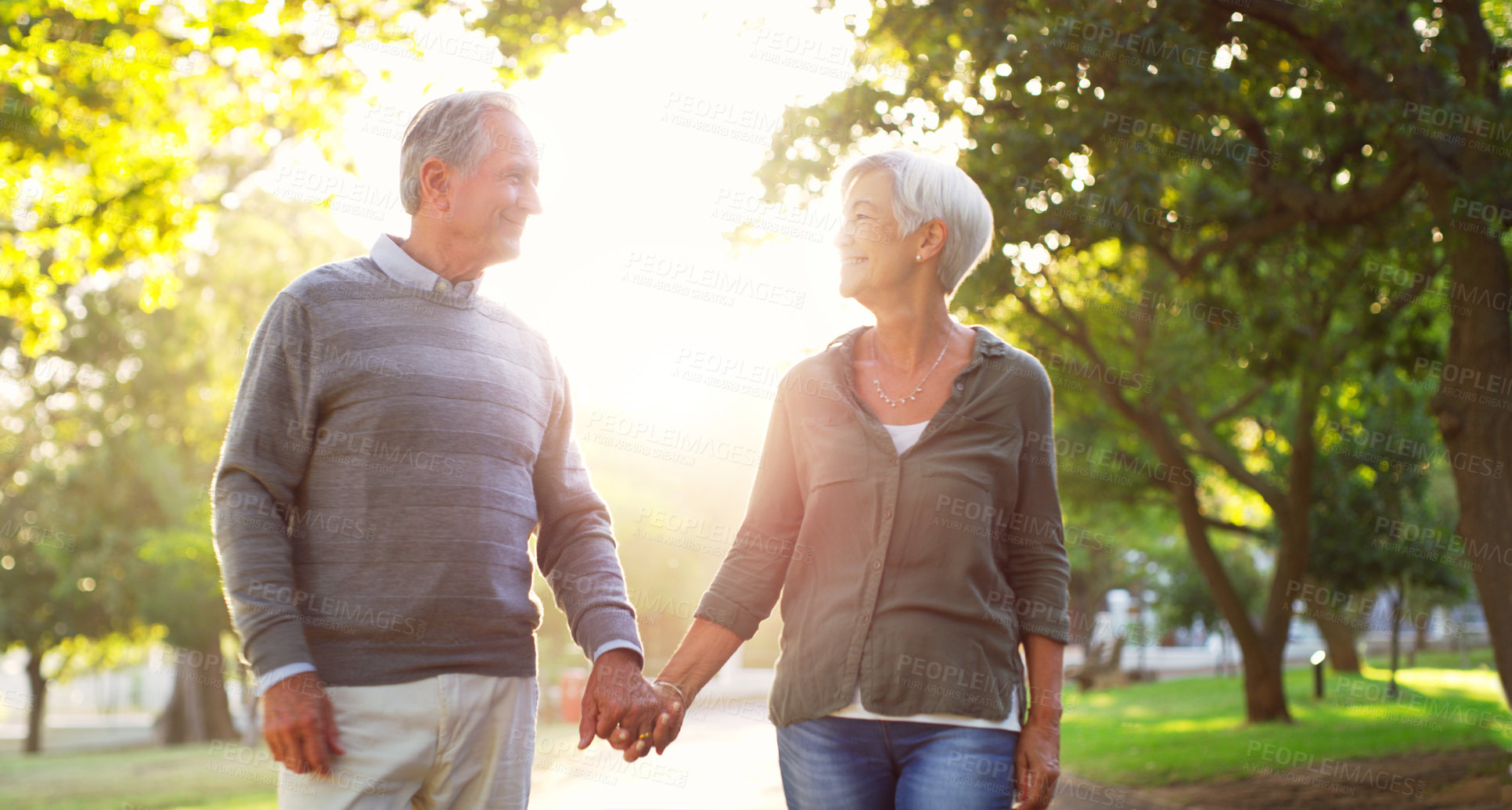 Buy stock photo Happy, walking and a senior couple outdoor at a park with love, care and support. A elderly man and woman holding hands in nature for commitment, quality time and healthy marriage or retirement