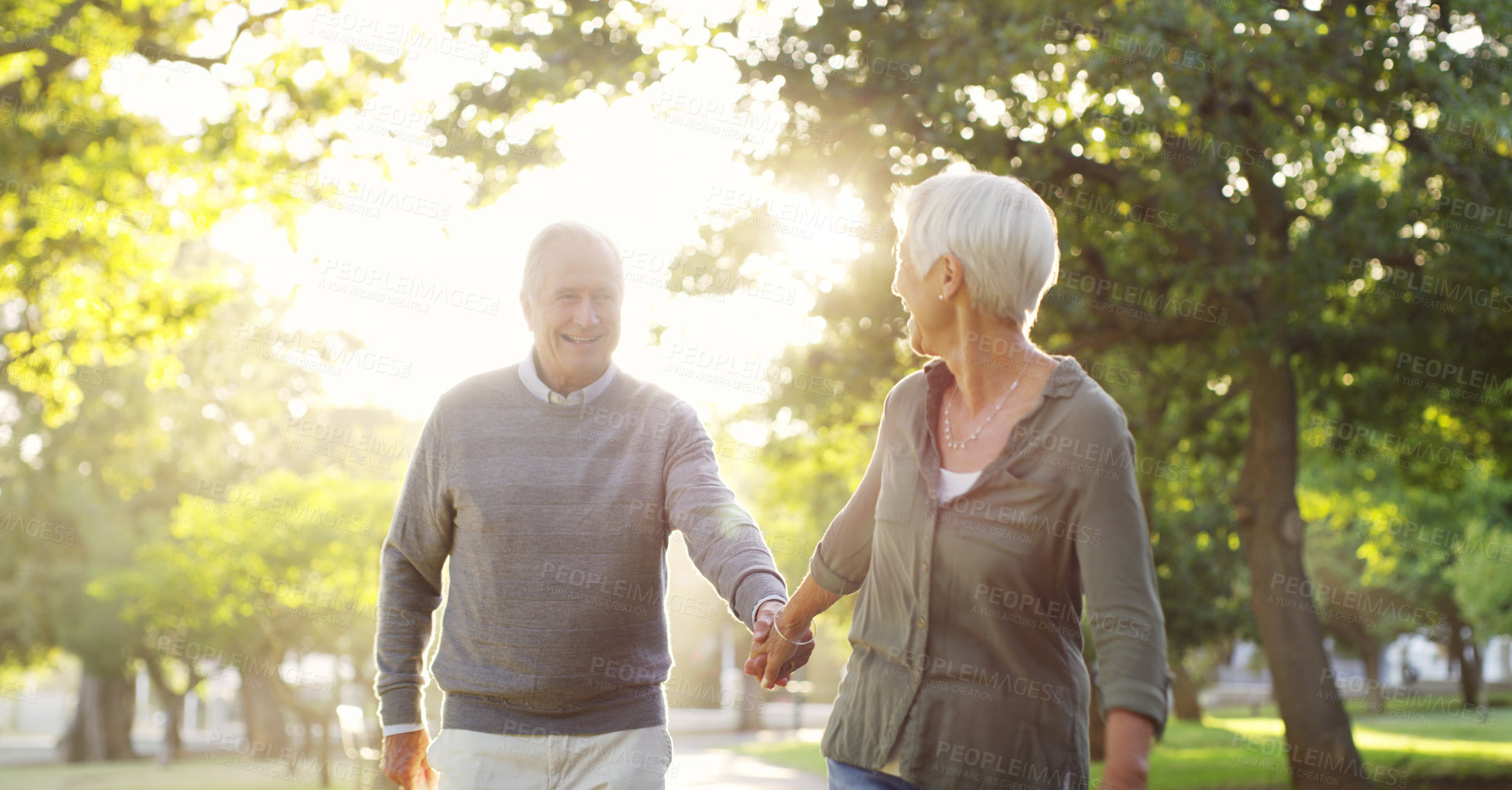 Buy stock photo Walking, holding hands and a senior couple outdoor at a park with a love, care and support. Elderly man and woman in nature to follow on a walk, quality time and happy marriage or healthy retirement