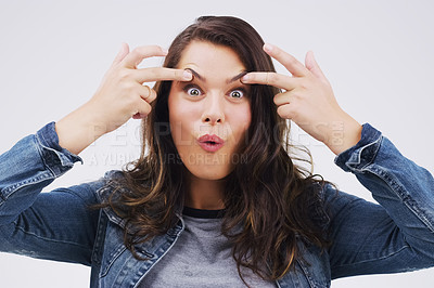 Buy stock photo Portrait, funny face and eyes with a woman in studio on a gray background looking silly or goofy. Comedy, comic and crazy with a playful young female person joking indoor for fun or carefree humor