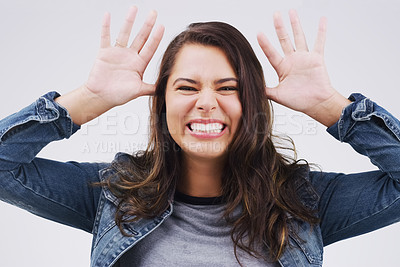 Buy stock photo Portrait, funny face and ears with a crazy woman joking in studio on a white background for humor. Comic, comedy and hands with a happy young female person feeling playful while smiling or having fun