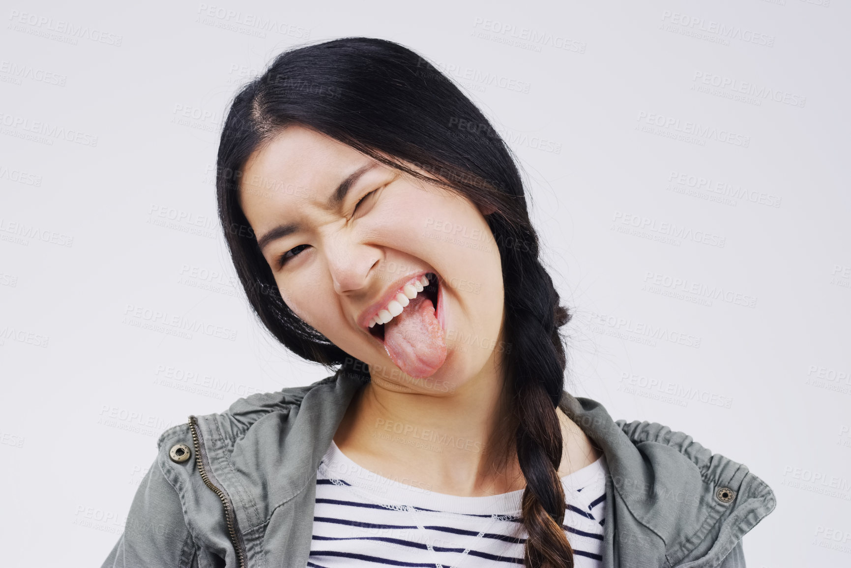 Buy stock photo Portrait, funny face and tongue with an asian woman in studio on a white background looking silly or goofy. Comedy, comic and wink with a crazy young female person joking indoor for fun or humor