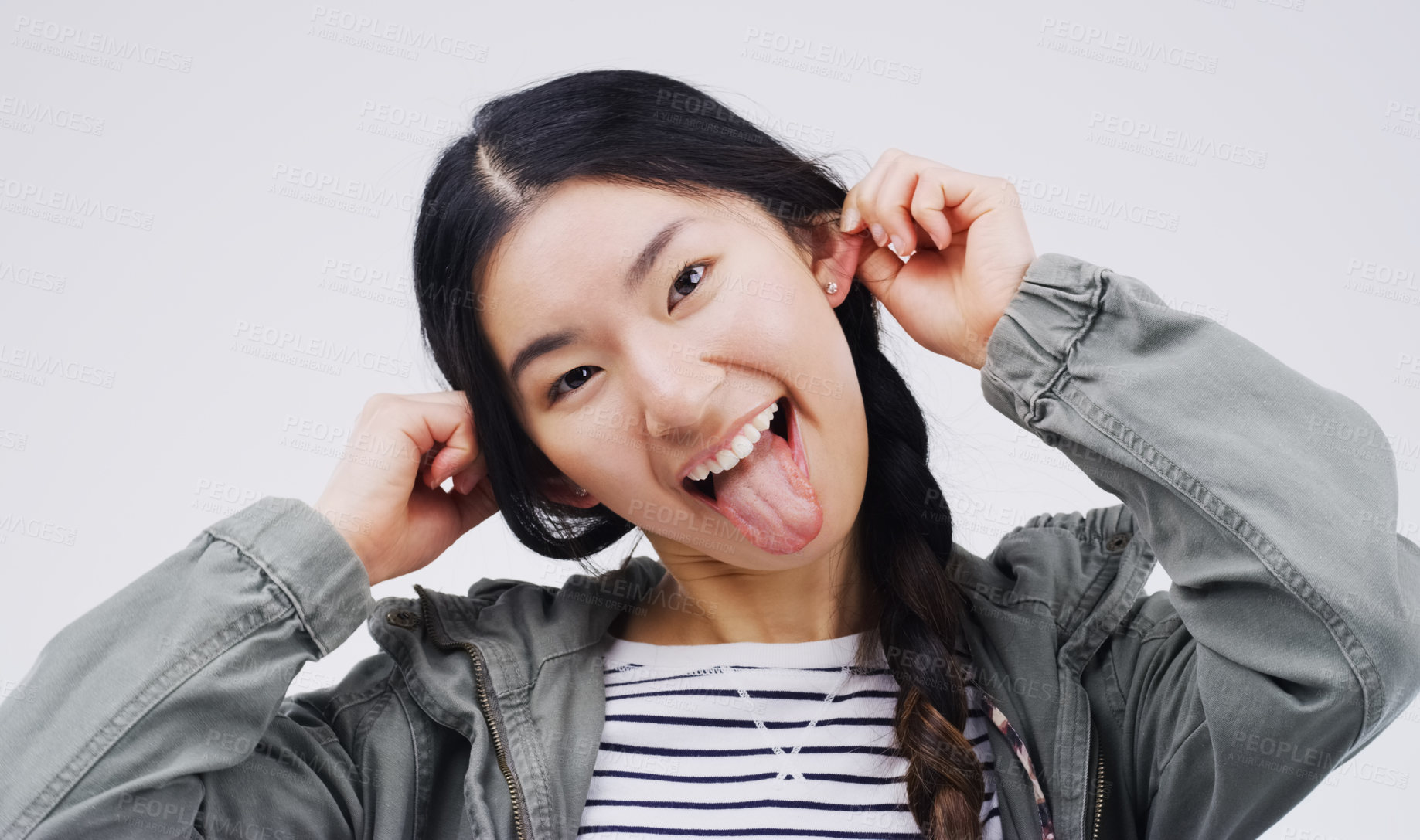Buy stock photo Portrait, funny face and ears with an asian woman in studio on a gray background looking silly or goofy. Comedy, comic and crazy with a playful young female person joking indoor for fun or humor