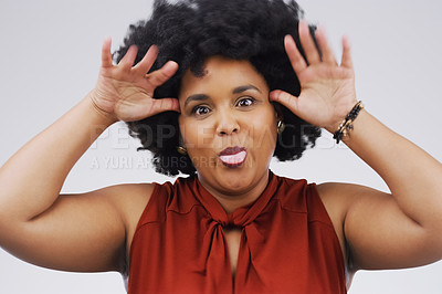 Buy stock photo Studio shot of a young woman making a funny face against a gray background