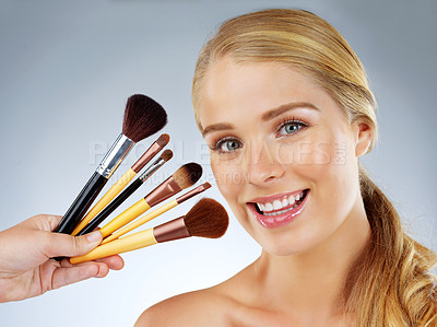 Buy stock photo Woman, portrait and beauty brushes in studio, transformation and choice on blue background. Female person, skincare and makeup tools or collection, facial treatment and decision for dermatology