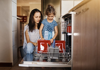 Buy stock photo Mother, kid and cleaning with dishwasher in kitchen for learning, independent or housework in home. Family, woman and girl with dirty plates in machine for hygiene, chores or help with washing dishes