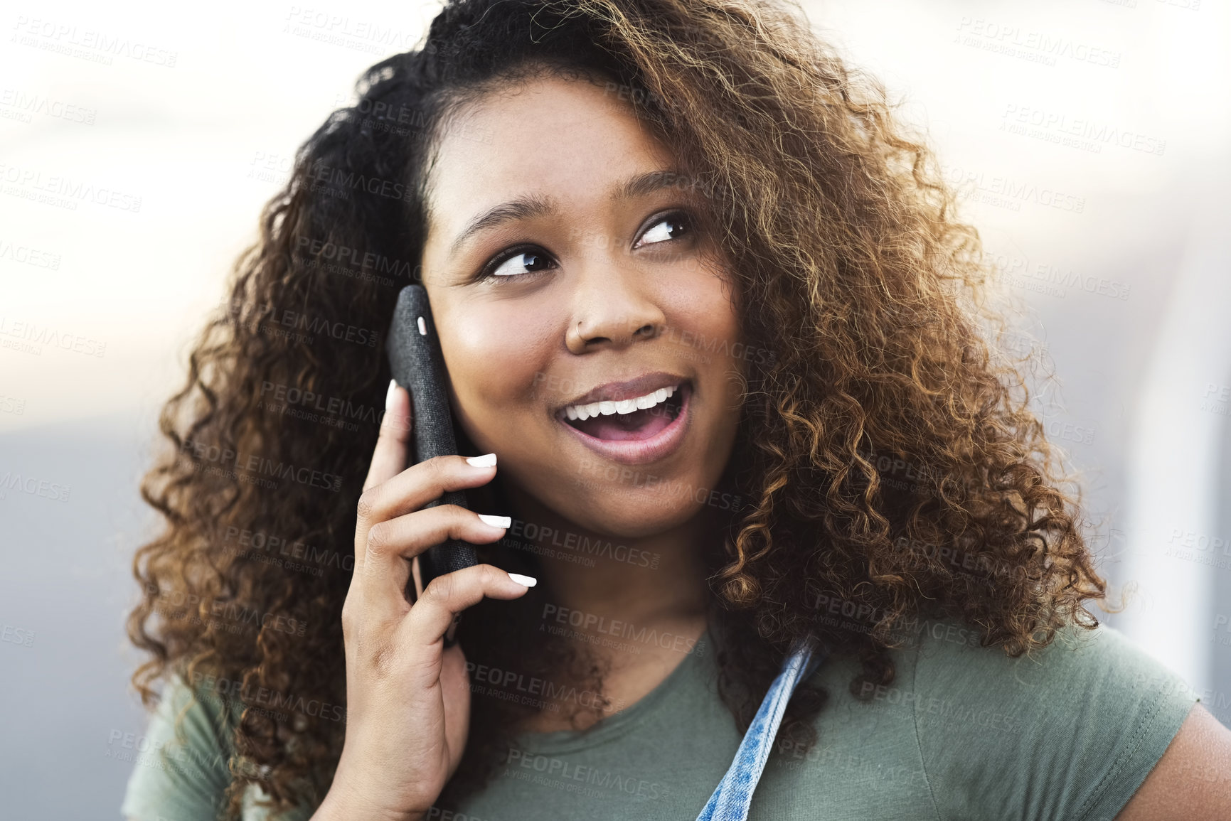 Buy stock photo Shot of an attractive young woman answering a call while walking through the city