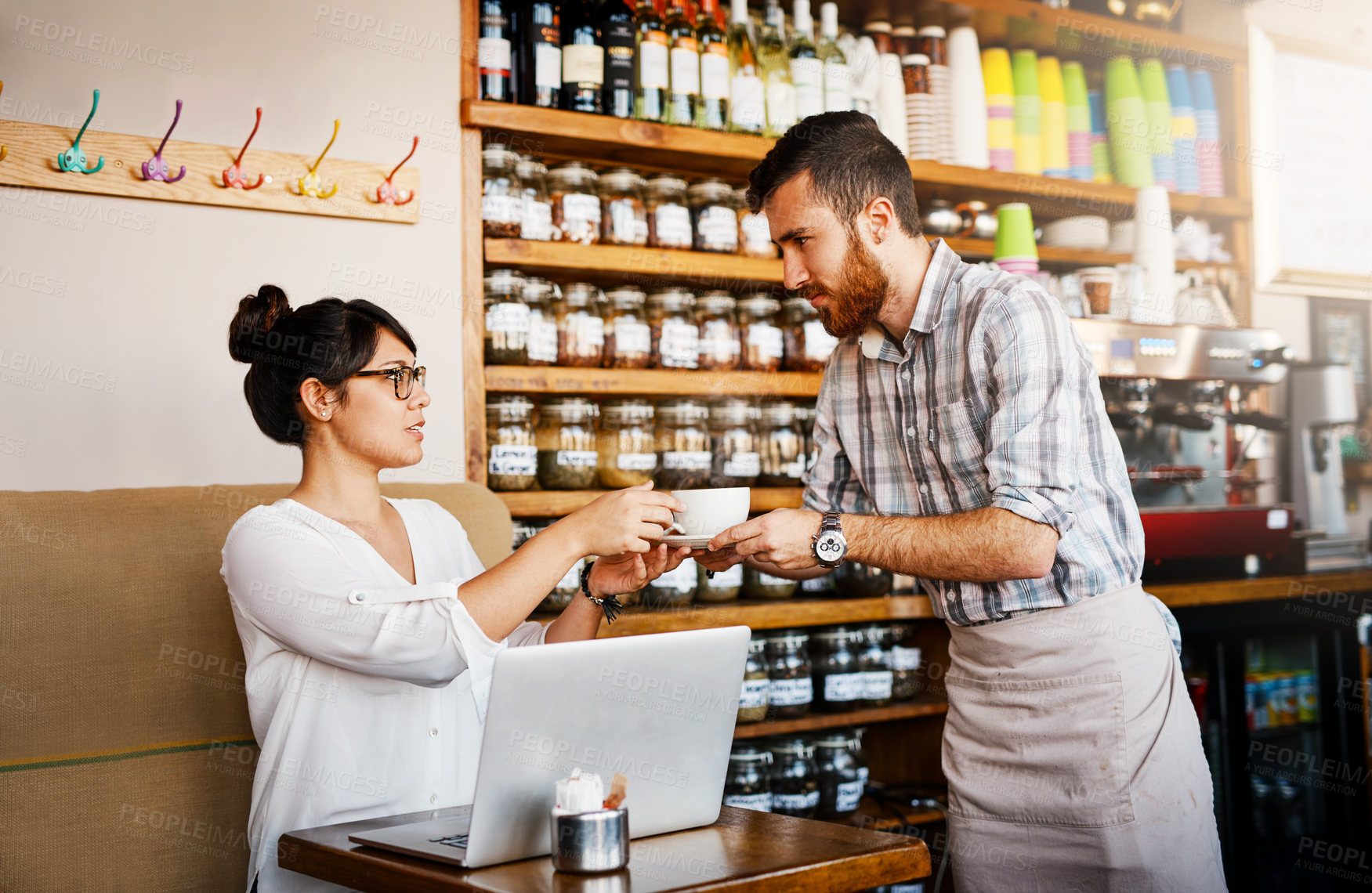 Buy stock photo Cropped shot of of an barista handing over a cup of coffee he just made to a customer inside of a cafe