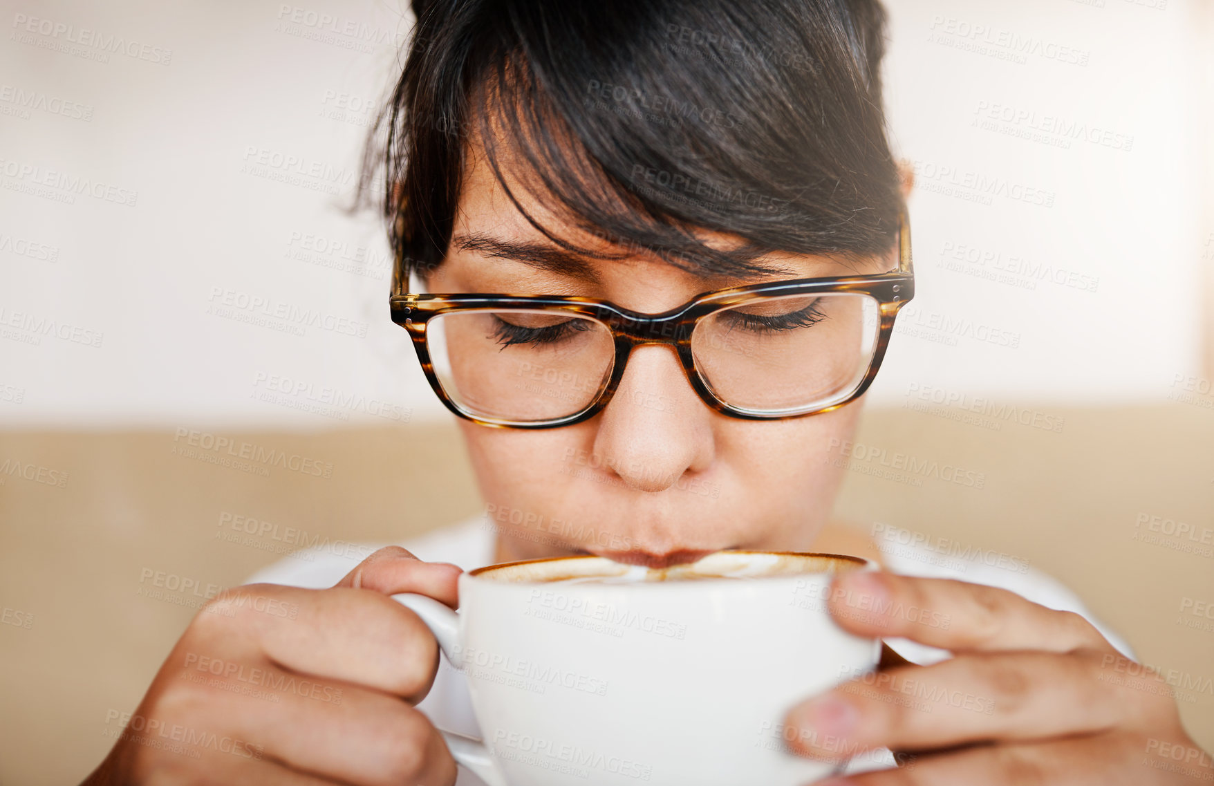 Buy stock photo Closeup of a beautiful young woman having a sip of her coffee she just bought inside of a cafe during the day