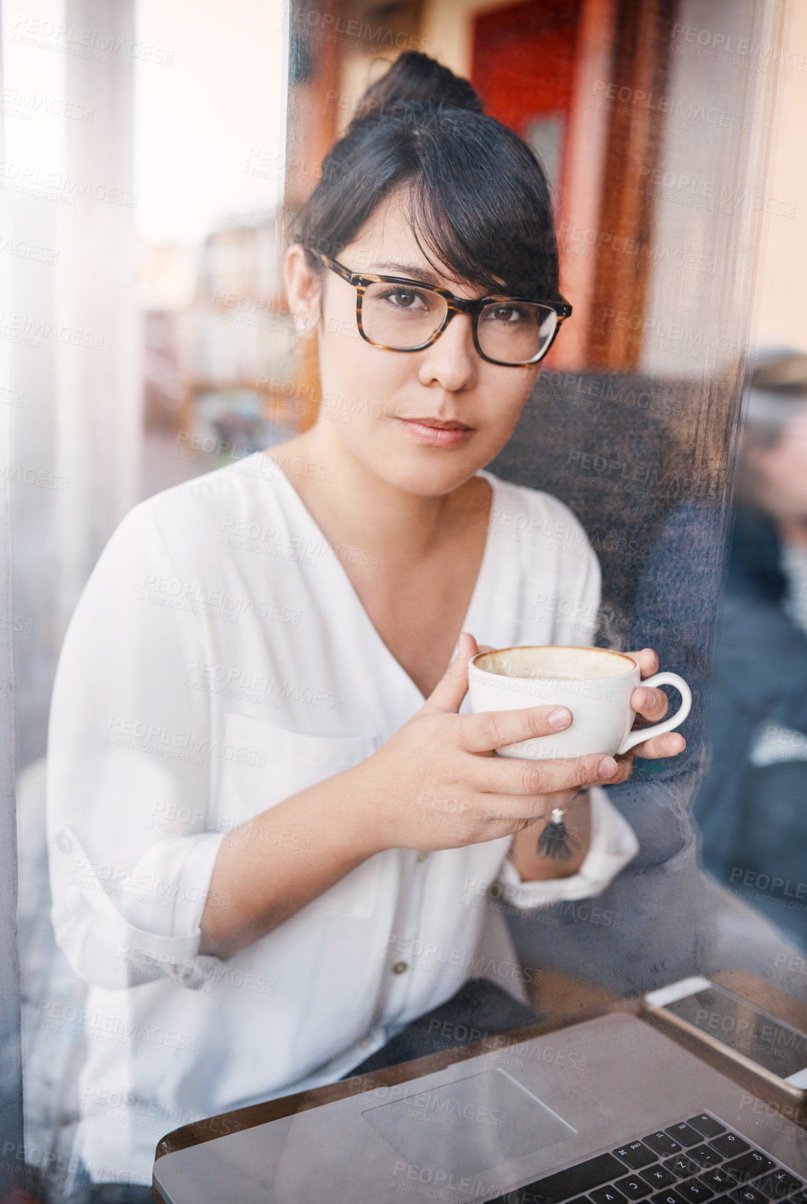 Buy stock photo Cropped shot of a beautiful young woman having a sip of her coffee she just bought inside of a cafe during the day