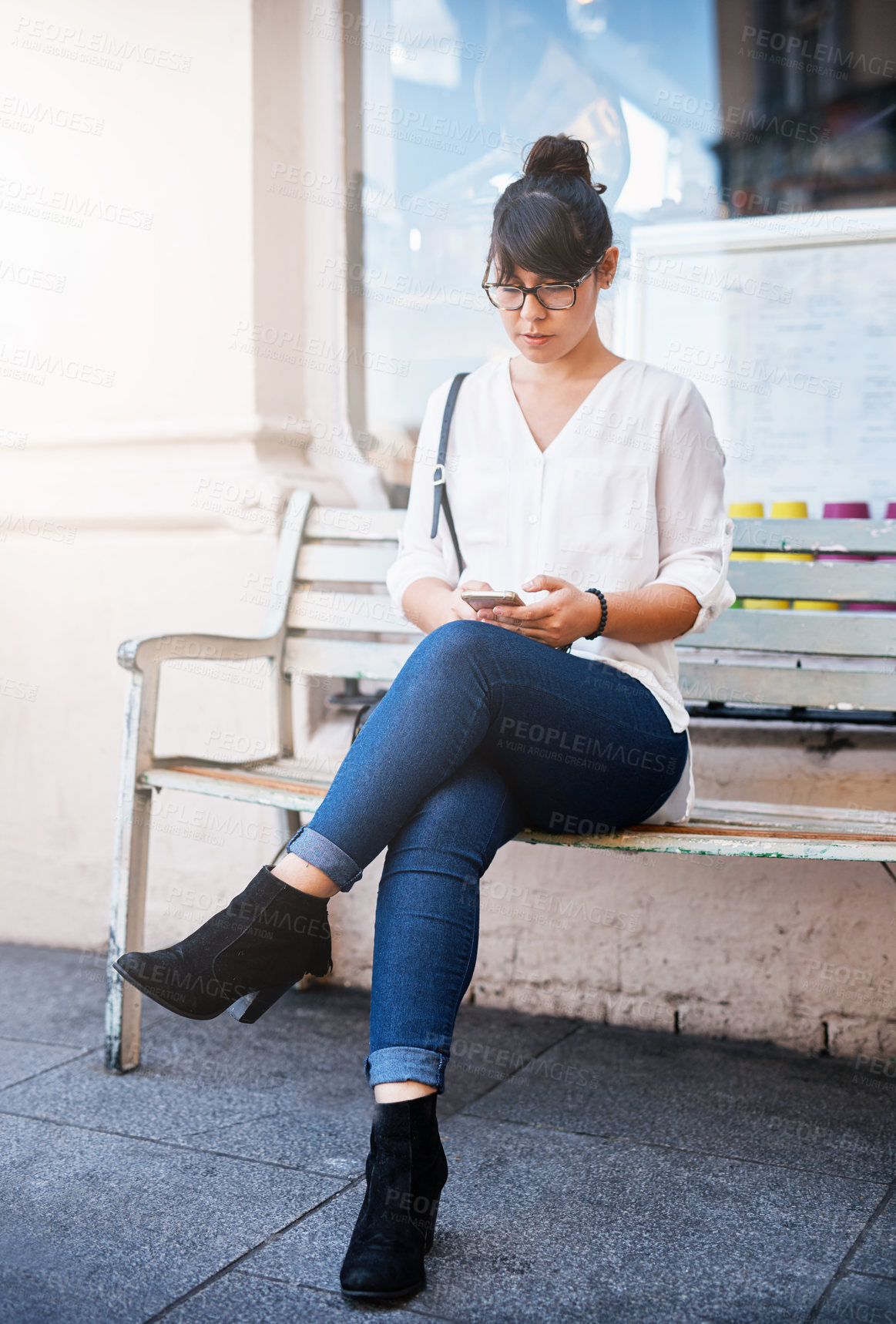 Buy stock photo Woman, phone and bench in city for travel, professional and street for morning networking. Female person, online and check news update in urban town, communication app and outdoor to relax on trip