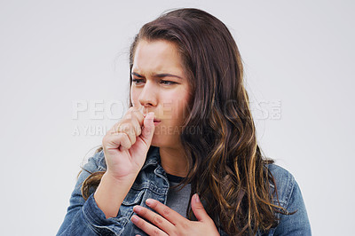 Buy stock photo Studio shot of an attractive young woman coughing against a grey background
