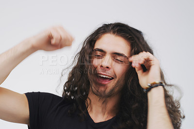 Buy stock photo Studio shot of a handsome young man looking cheerful and dancing against a grey background