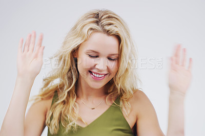 Buy stock photo Studio shot of an attractive young woman feeling cheerful and dancing against a grey background