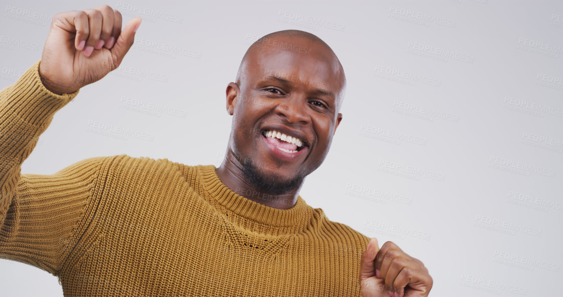 Buy stock photo Studio portrait of a handsome young man feeling cheerful and dancing against a grey background