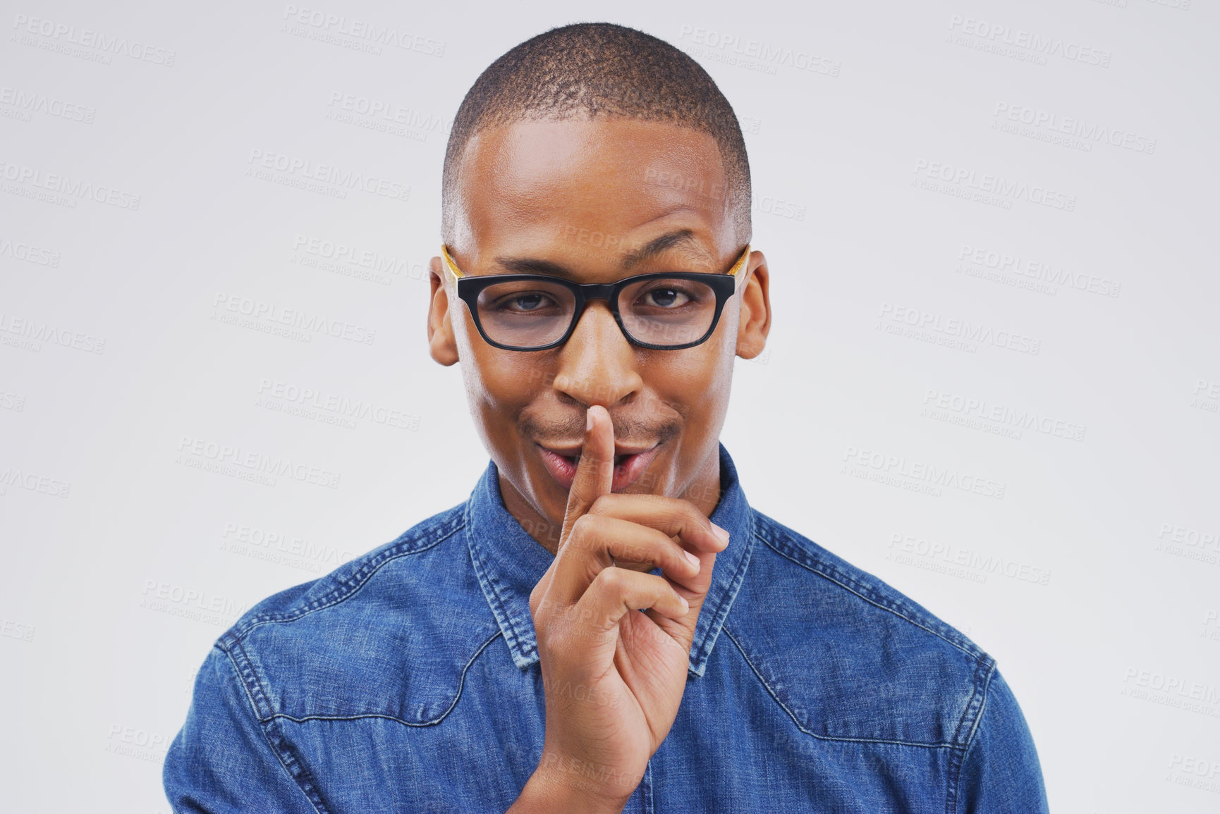 Buy stock photo Portrait, silent and shush with private black man in studio isolated on gray background for mystery. Face, finger on lips and secret with emoji hand gesture of confident person to whisper gossip