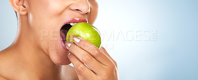 Buy stock photo Bite, apple or mouth of woman eating for healthy choice or benefits mockup space on blue background. Fresh, hand or vegan girl in studio for fruit or food for fiber, detox diet or vitamin c nutrition