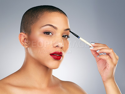 Buy stock photo Studio shot of a beautiful young woman applying makeup against a grey background