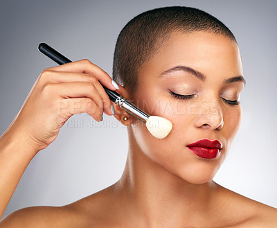 Buy stock photo Studio shot of a beautiful young woman applying makeup against a grey background
