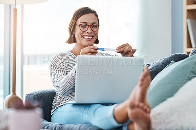 Buy stock photo Full length shot of a happy young woman looking at a pregnancy test while using a laptop at home