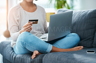 Buy stock photo Cropped shot of an unrecognizable young woman using her laptop and credit card in her living room