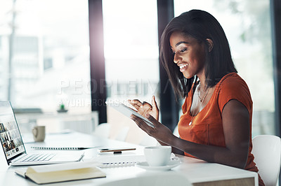Buy stock photo Shot of an attractive young businesswoman using her digital tablet at her office desk at work