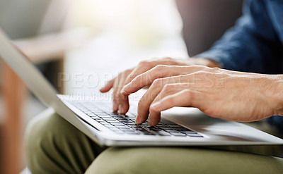 Buy stock photo Cropped shot of an unrecognizable man using a laptop in his living room at home