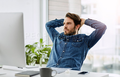 Buy stock photo Cropped shot of a handsome young businessman looking thoughtful while sitting with his hands behind his head in a modern office
