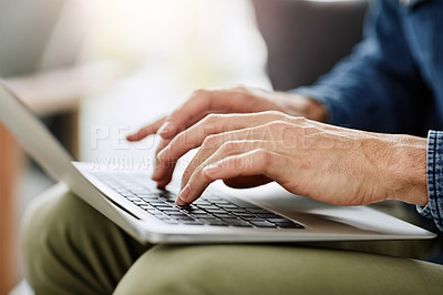 Buy stock photo Cropped shot of an unrecognizable man using a laptop in his living room at home