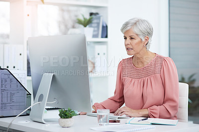 Buy stock photo Shot of a mature businesswoman working on a computer in her office