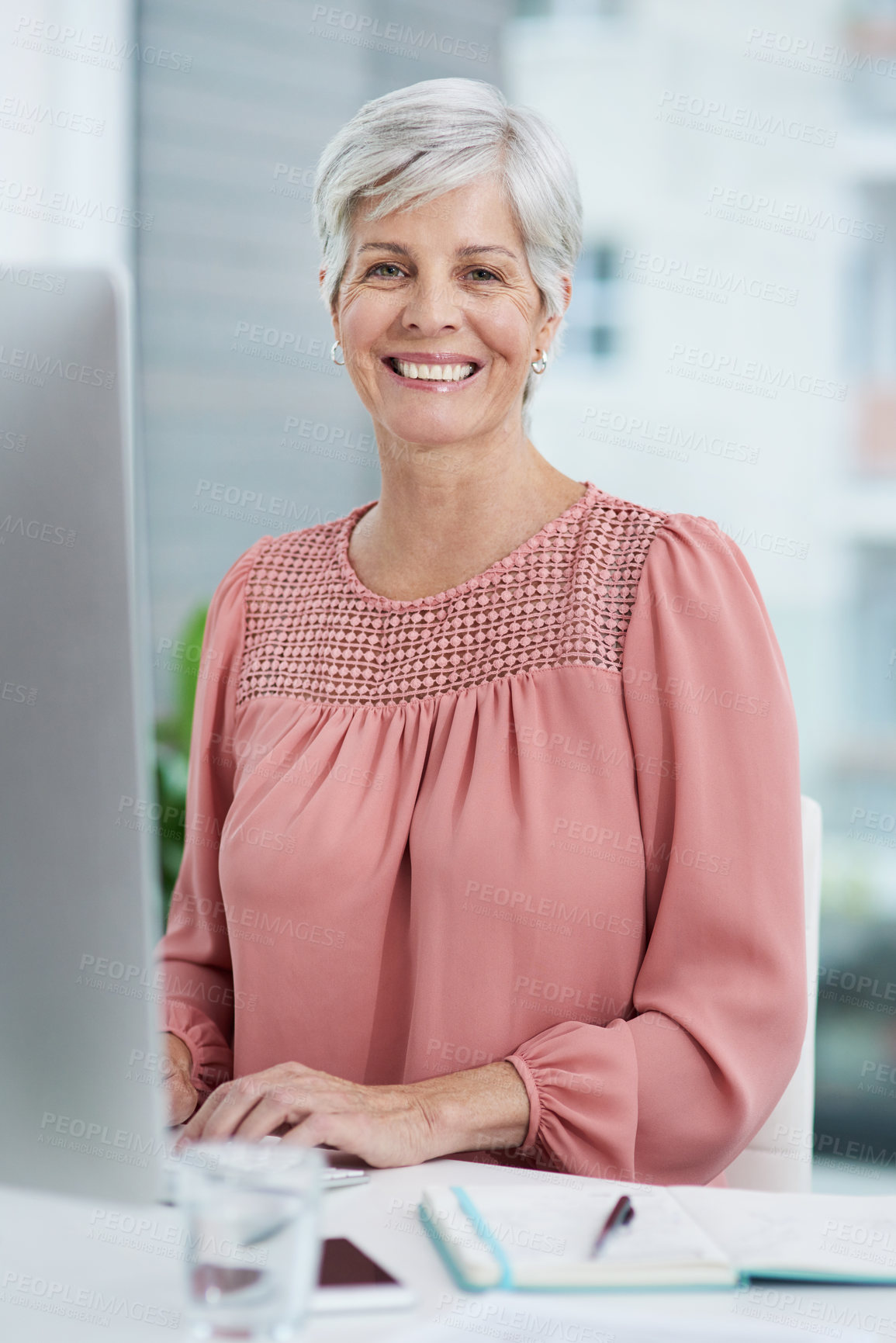Buy stock photo Portrait of a mature businesswoman working on a computer in her office