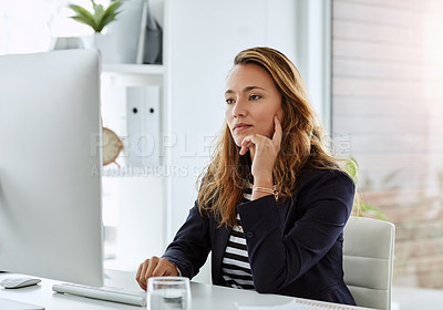 Buy stock photo Shot of an attractive businesswoman looking thoughtful while working on a computer in her office