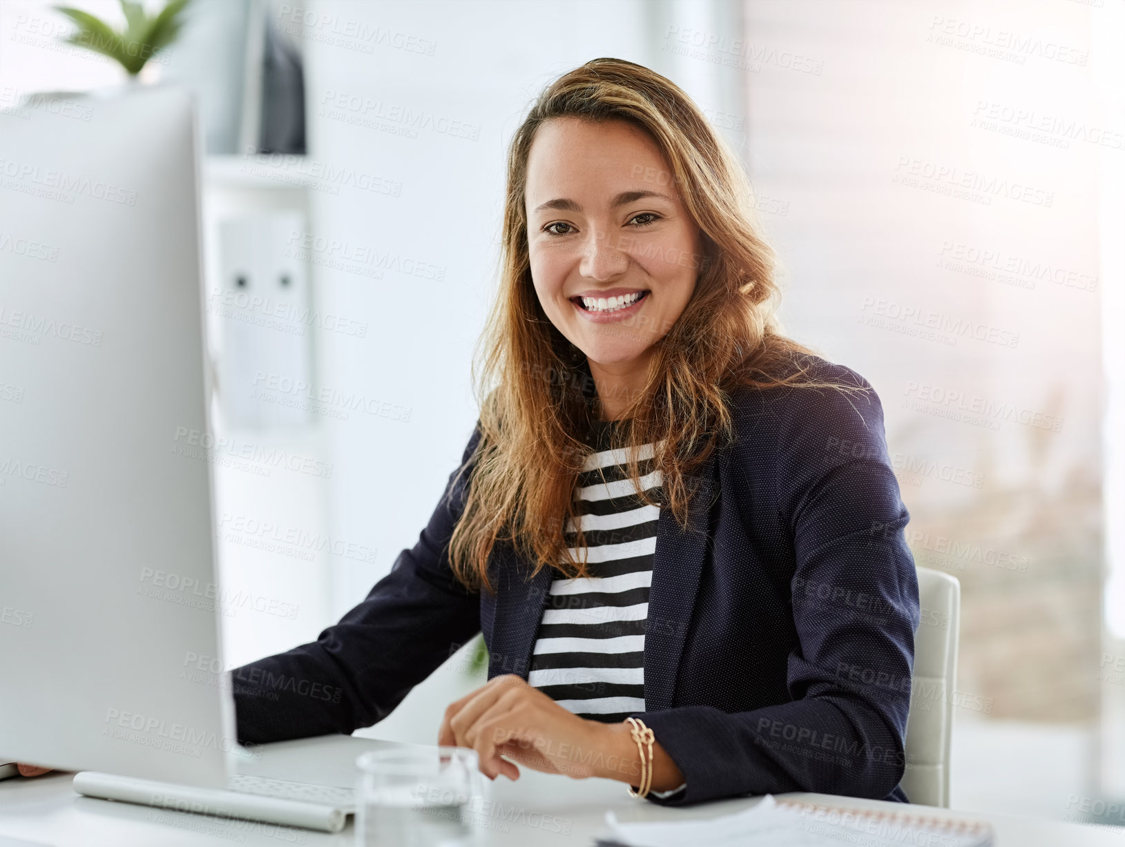 Buy stock photo Portrait of a cheerful businesswoman working on a computer in her office