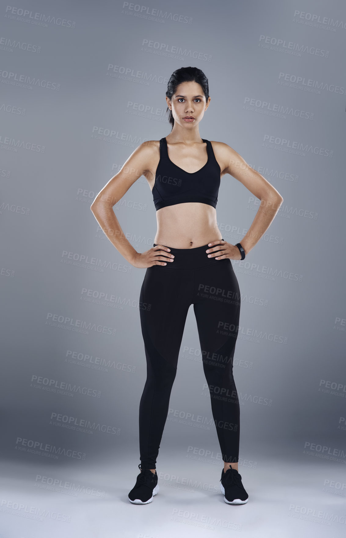 Buy stock photo Full length shot of a sporty young woman posing with her hands on her hips  against a grey background