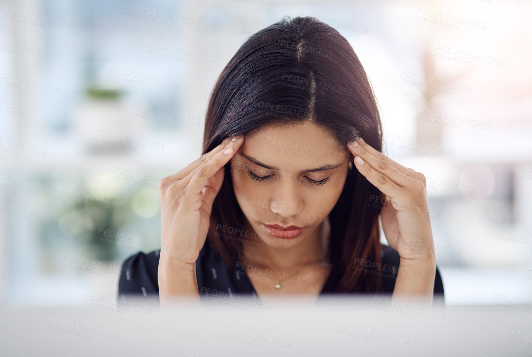 Buy stock photo Shot of an attractive young businesswoman suffering from a headache in her office at work