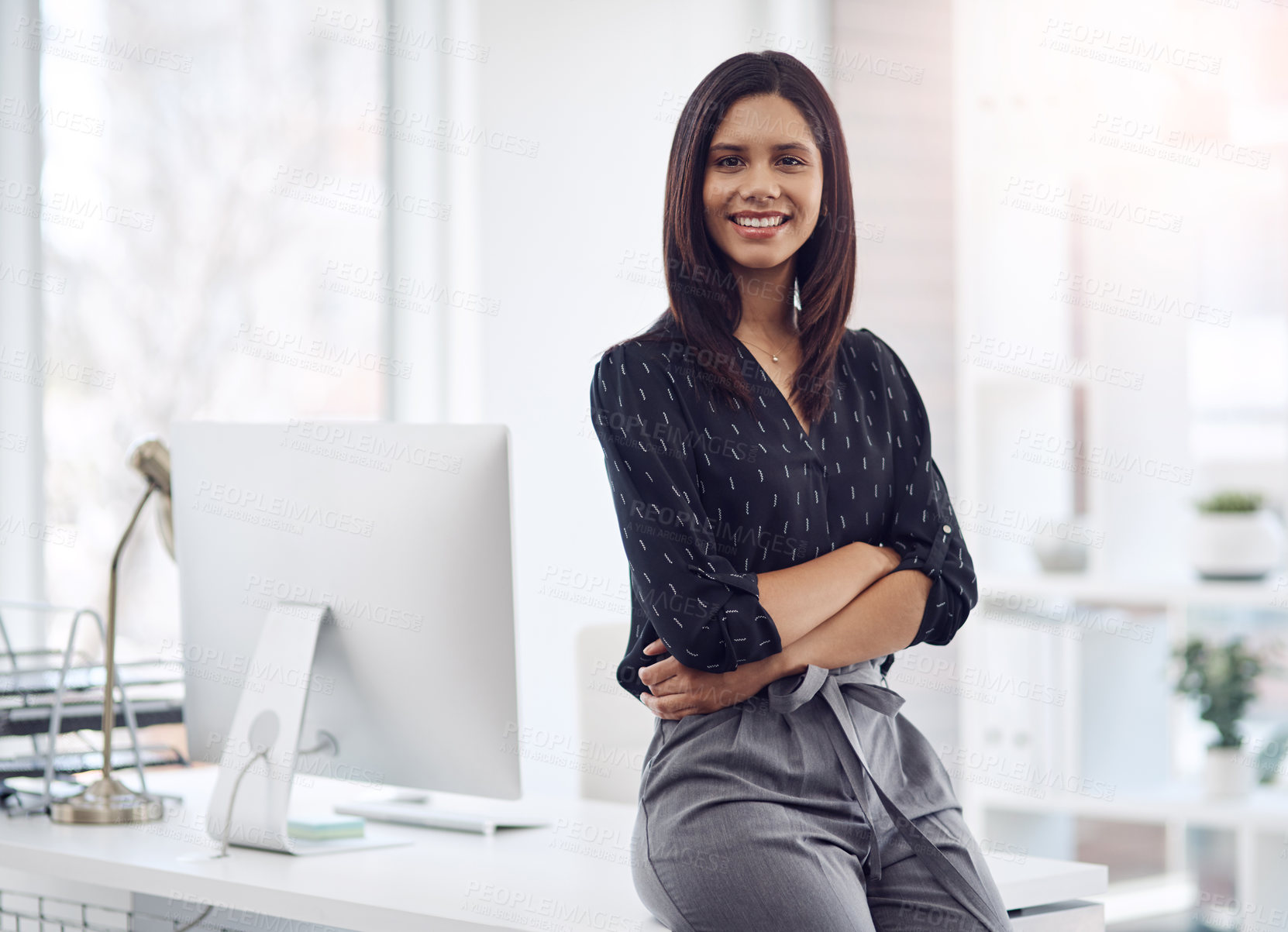 Buy stock photo Portrait of an attractive young businesswoman posing with her arms folded in her office at work