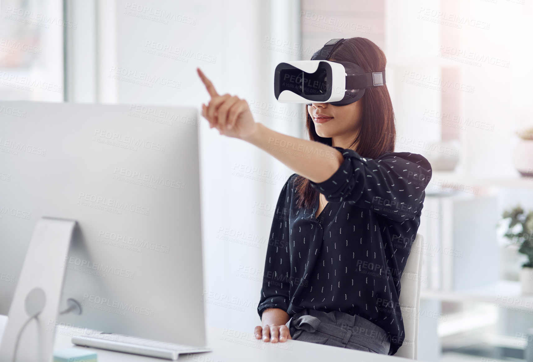 Buy stock photo Shot of a young businesswoman wearing a VR headset while working in her office