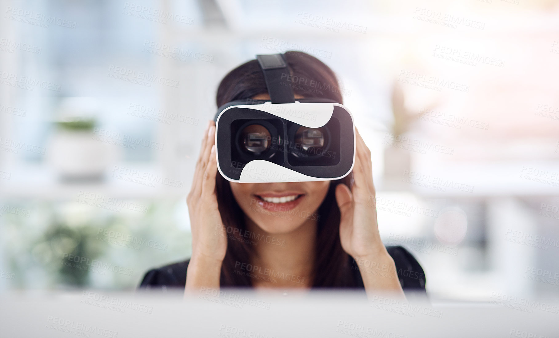 Buy stock photo Shot of a young businesswoman wearing a VR headset while working in her office