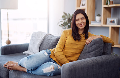 Buy stock photo Portrait of an attractive young woman relaxing on her sofa at home