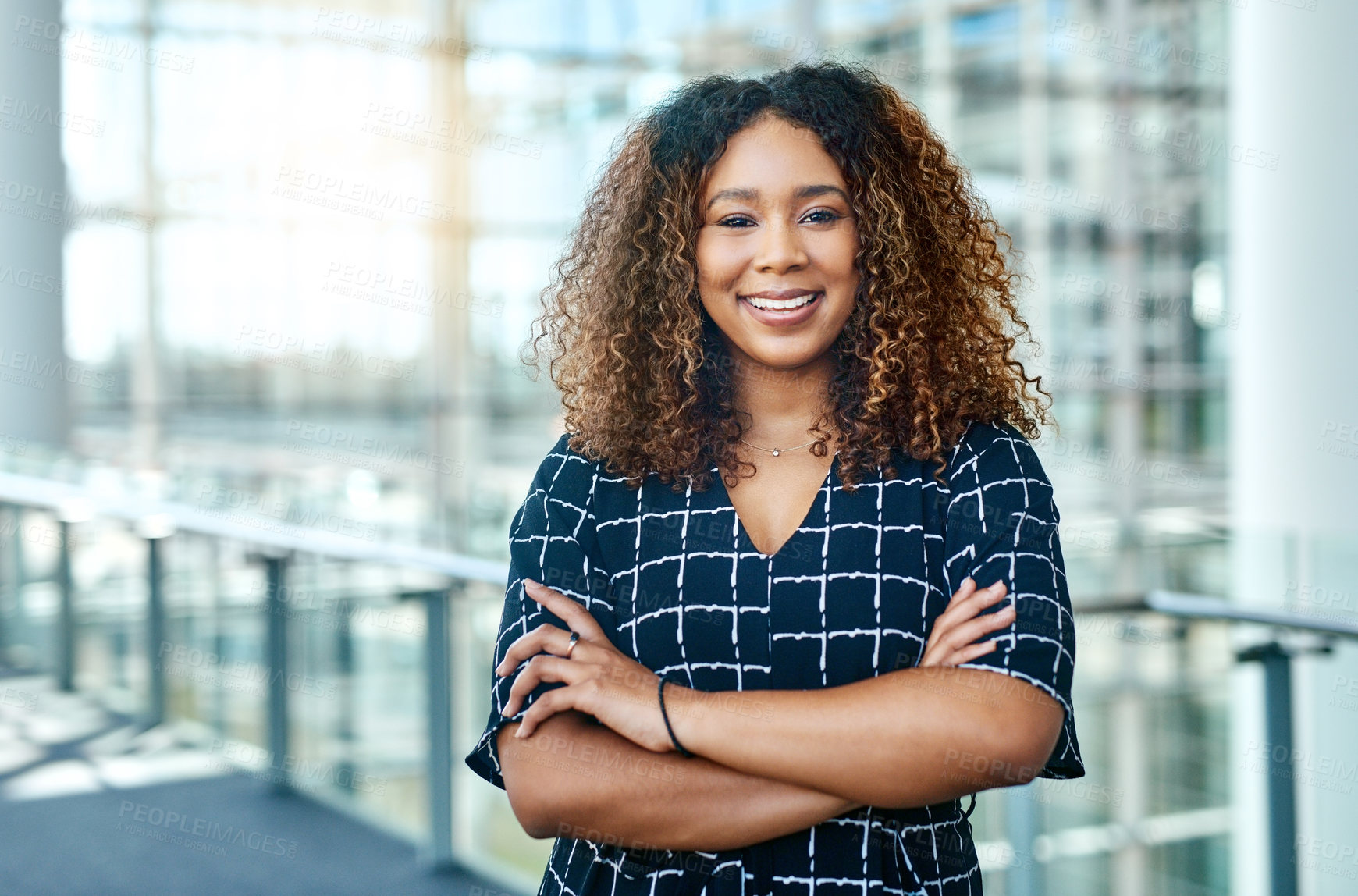 Buy stock photo Cropped portrait of an attractive young businesswoman standing with her arms folded in a modern office