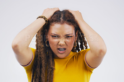 Buy stock photo Studio portrait of an attractive young woman looking stressed out against a grey background