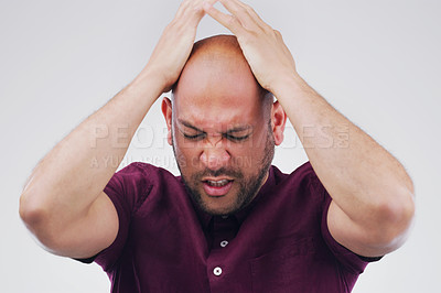 Buy stock photo Studio shot of a handsome young man looking stressed out against a grey background