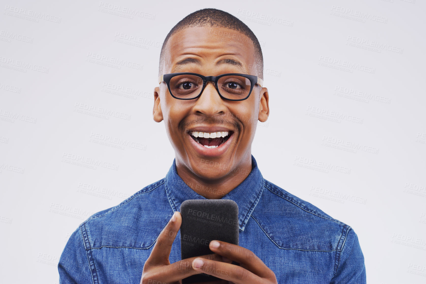 Buy stock photo Studio shot of a handsome young man using his cellphone