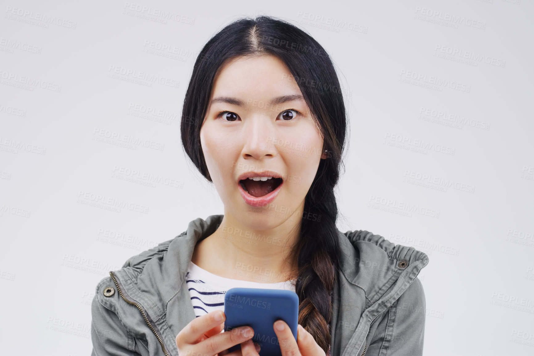 Buy stock photo Asian woman, smartphone and surprised in portrait for social media, text and secret in studio. Reading, cellphone and female person on internet for wow, gossip and watch video on white background