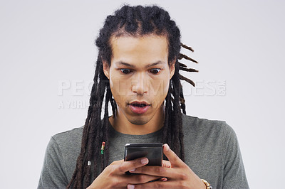 Buy stock photo Studio shot of a handsome young man using his cellphone