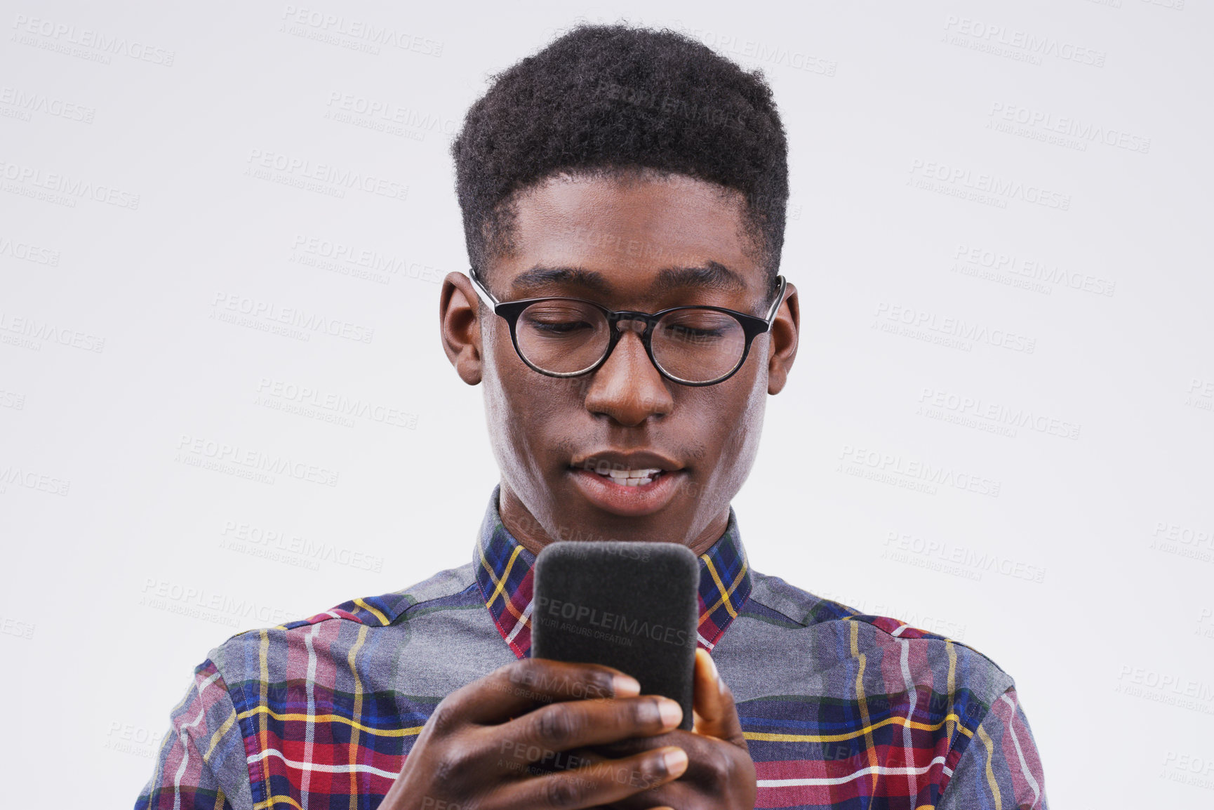 Buy stock photo Studio shot of a handsome man using his cellphone against a grey background