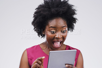 Buy stock photo Studio shot of a young woman using a digital tablet against a grey background