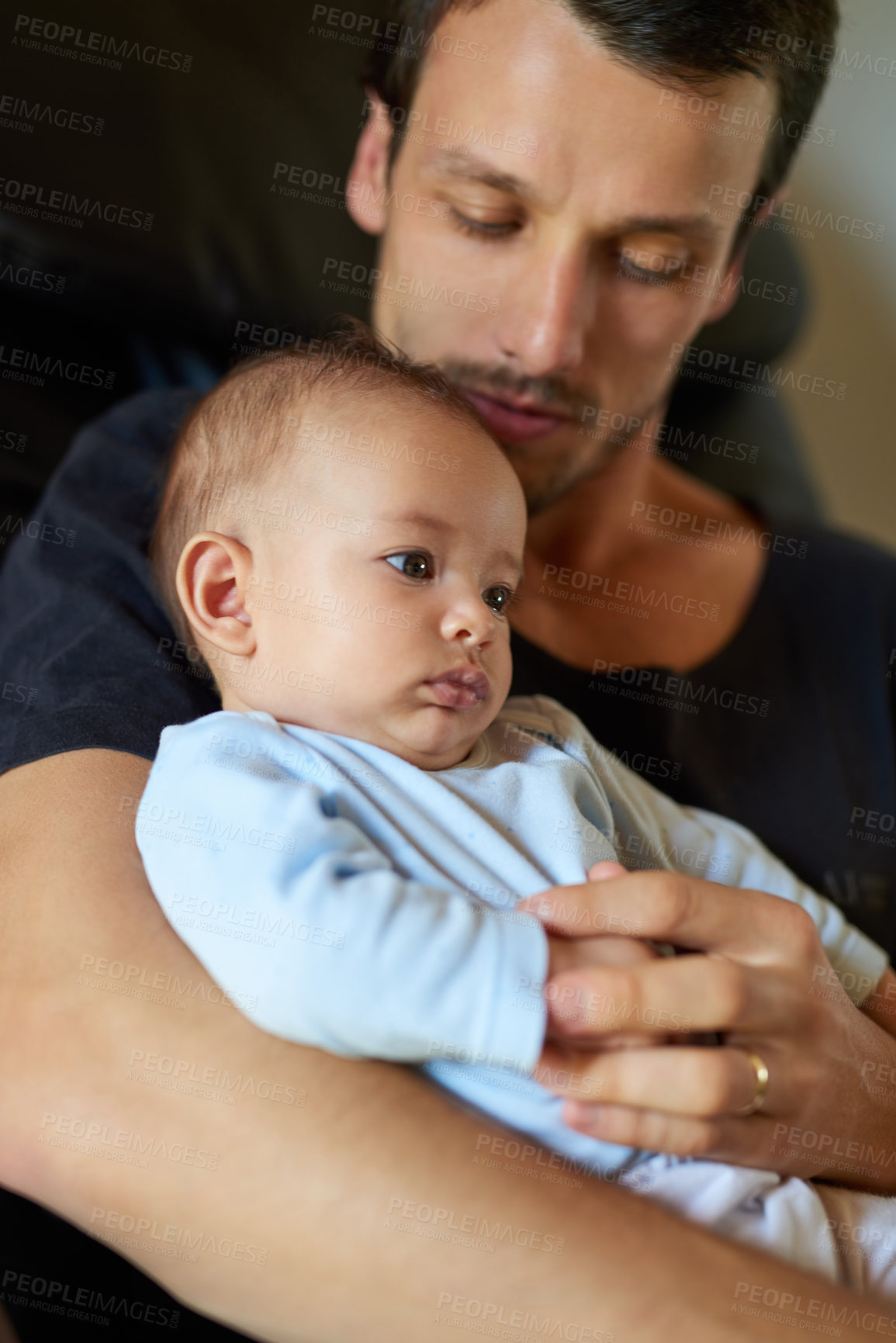 Buy stock photo Shot of an affectionate young father holding and bonding with his infant son at home