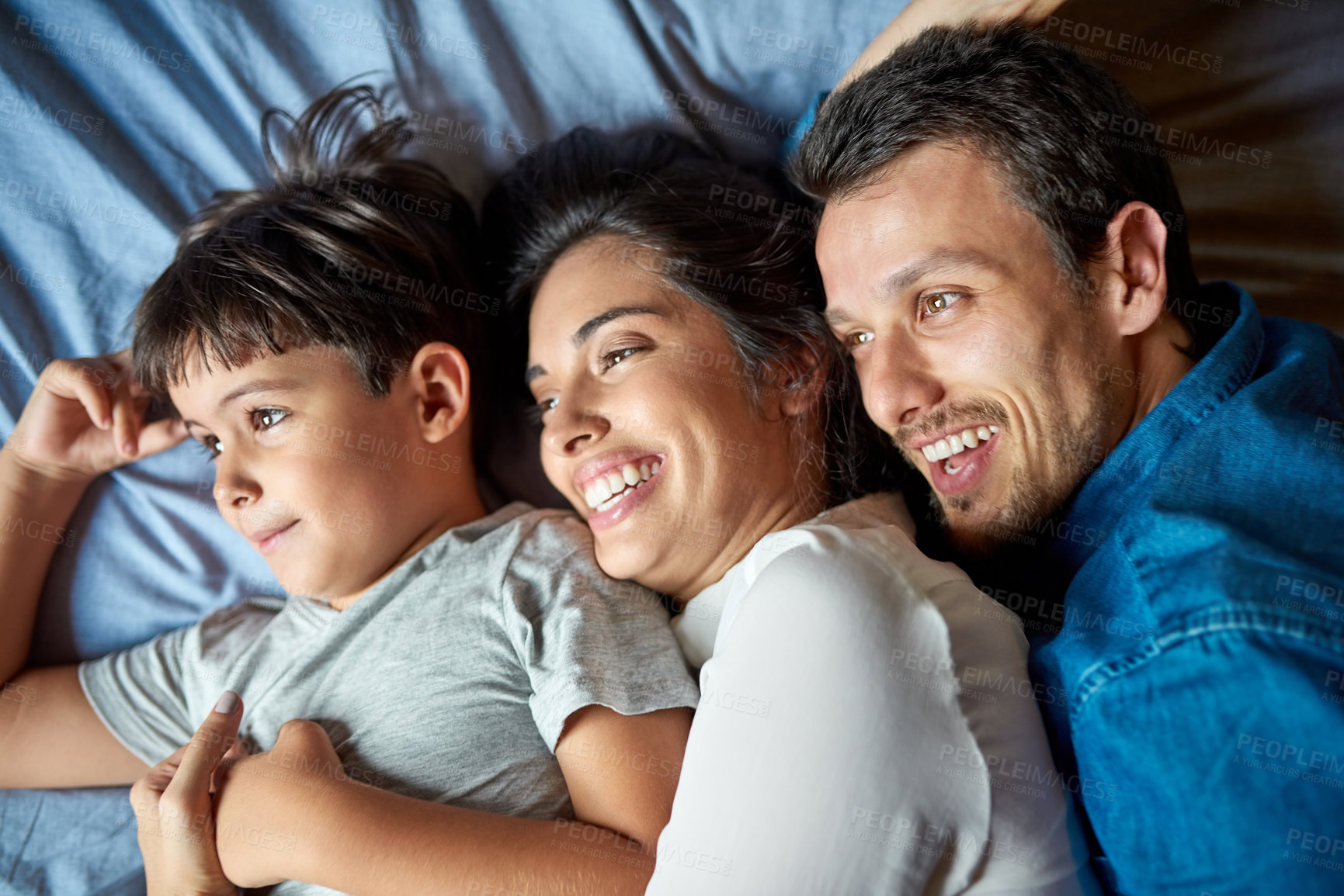 Buy stock photo Shot of a beautiful young couple and their son laying in bed together at home